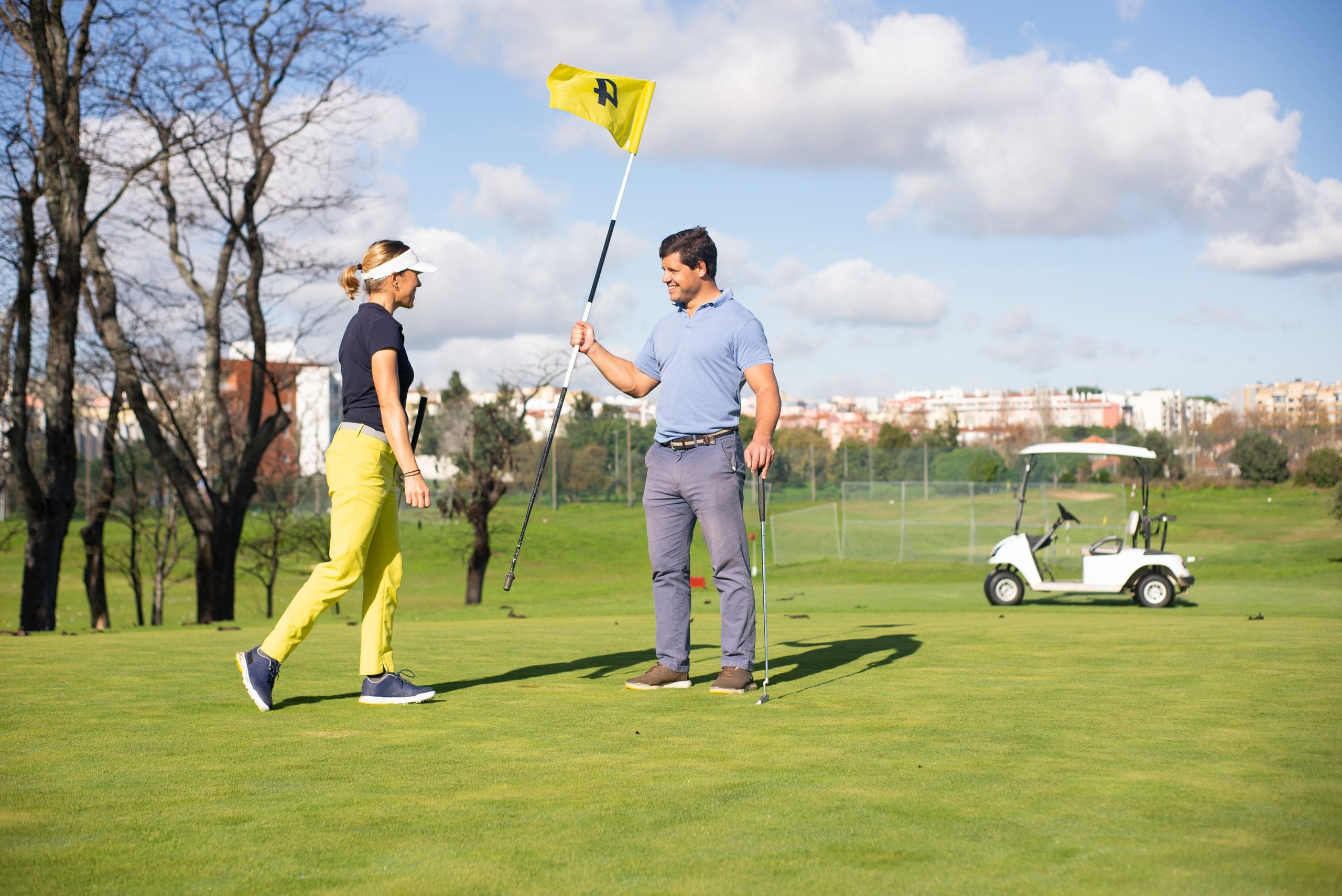 A caddie and golfer reading the line of a green together at first light